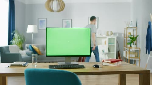Modern Personal Computer with Mock-up Green Screen Display Standing on the Desk of the Cozy Home Of