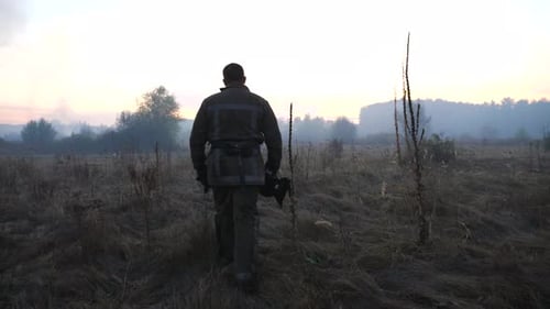Firefighter Walks Towards Distant Wildfire at Sunrise