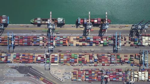 Hafendock mit Schiffscontainern, Transtainerkranen, Neuwagen und Containerschiff
