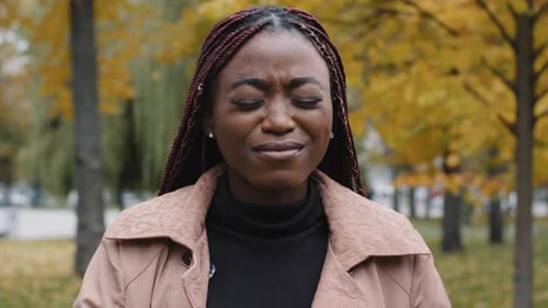 Closeup Annoyed African American Young Woman Standing Outdoors Covering Ears with Hands From Loud