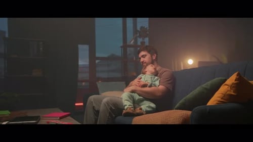 Dad Holding Baby on Couch at Night