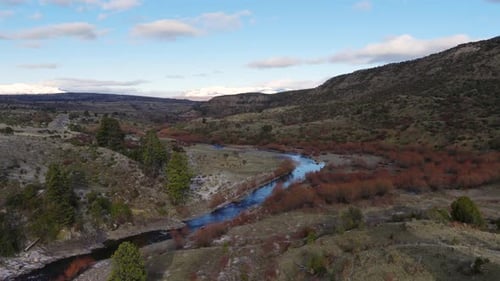 Panorama drone view of Patagonian landscape of river curving through mountain valley, Argentina.