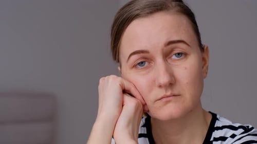 Nahaufnahme einer traurigen, nachdenklichen Frau, die alleine sitzt und über Beziehungen und persönliche Probleme nachdenkt