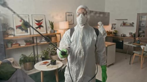 People in Suits Disinfecting Home Interior
