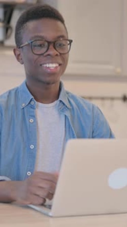 Young Man Video Conferencing with Laptop at Home