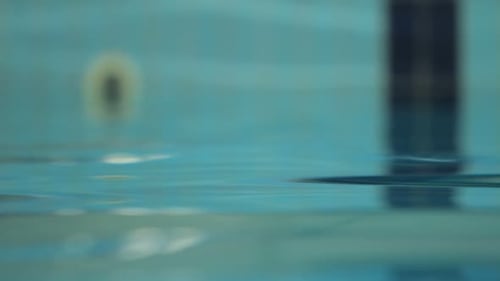 Shiny ripples on the swimming pool water surface reflecting sunlight