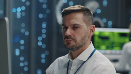 A Man with a Beard Works in a Hightech Server Room Focused