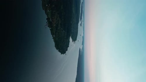 Aerial Vertical Shot From a Camera Flying Over a Wide River Among Forest