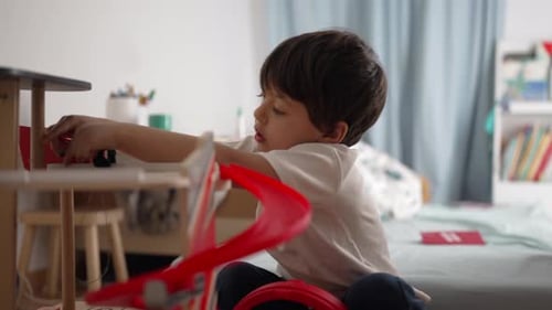 Child Playing with Toy Car Garage in Bedroom