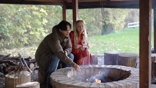 Couple Roasting Marshmallows on an Autumn Campfire