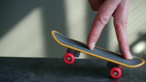 Close Up of Fingers Riding a Miniature Skateboard Toy