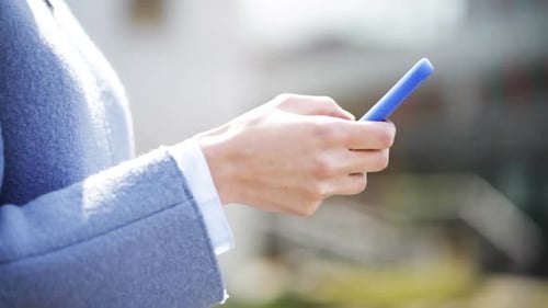 Businesswoman texting on smartphone in the city connecting with modern technology