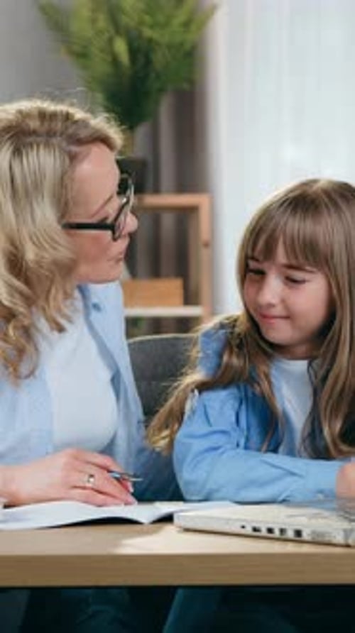 Blond Woman Helping Young Girl with Homework