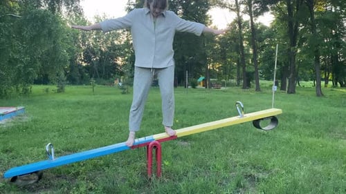Barefoot Female Person Finds Equilibrium on Playground Outdoors