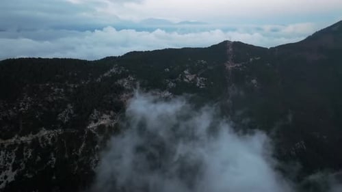 Aerial View of Mountain Peaks Shrouded in Clouds