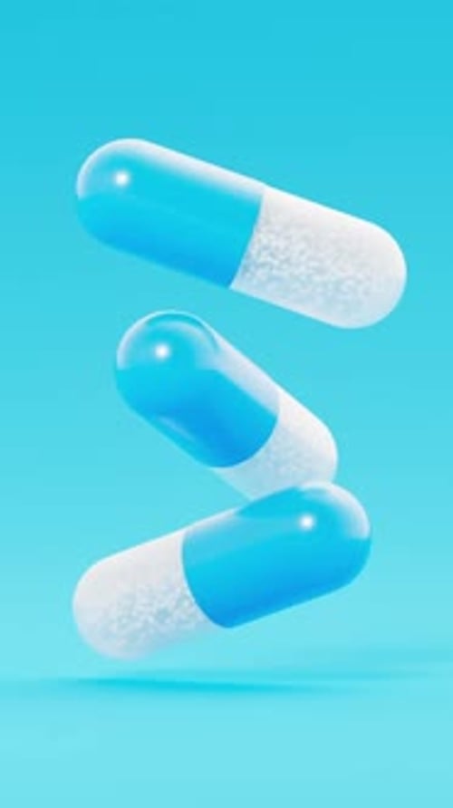 Blue and White Pills Floating on Light Blue