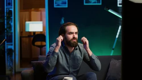 Man Reacts to TV in Disbelief and Frustration