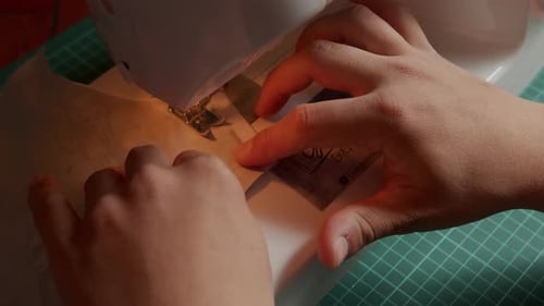 Hands Sewing Fabric on Machine Close Up