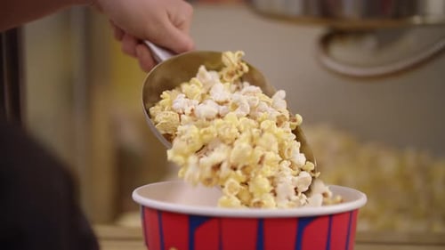 Popcorn Pouring in Container with Ladle in . Ready Popcorn Flakes