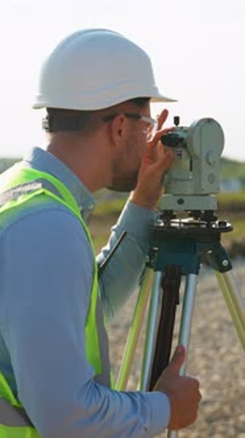 Ingénieur géomètre utilisant le niveau de théodolite sur un chantier de construction