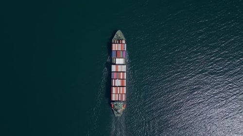 Ein Containerschiff bewegt sich stetig mit gestapelten Containern durch den Ozean