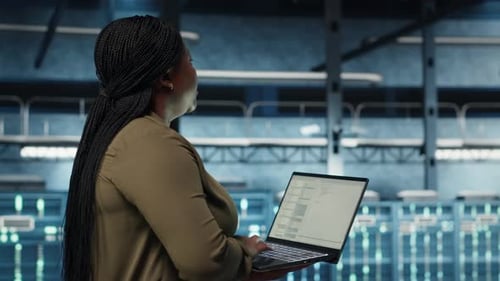 Engineer Walks in Server Hub Using Laptop to Upgrade Rigs