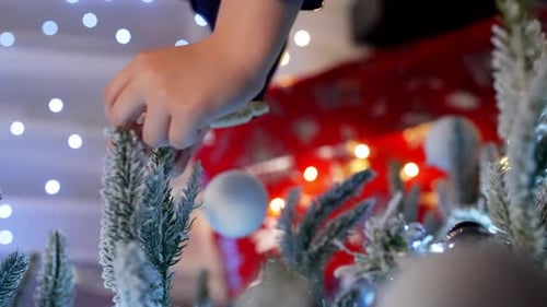 Child decorating Christmas tree with ornament