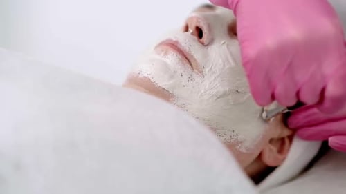 Close Up Cosmetician Hands in Pink Gloves Applying a Facial Beauty Mask Using a Brush