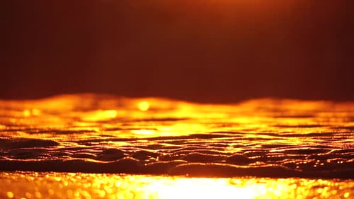 Kleine Meereswelle verschwommene weiche, schaumige Wellen waschen goldenen Sandstrand bei Sonnenuntergang Ozeanwellen auf Sand