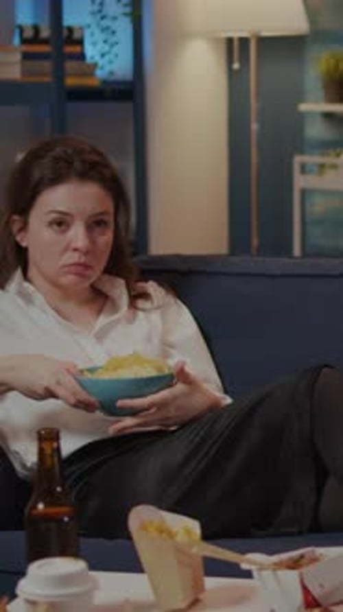 Vertical Video Caucasian Adult Relaxing on Couch with Chips As Snack