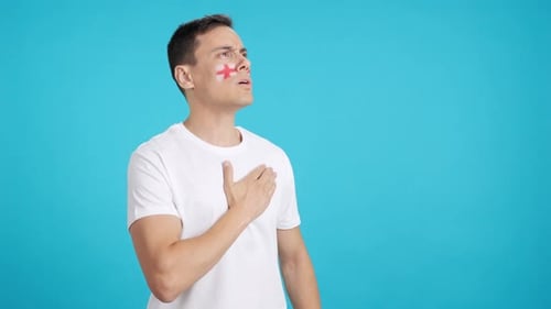 Man with Face Paint Puts Hand Over Heart