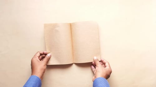 Top View of Man's Hand Turning a Pager of a Diary