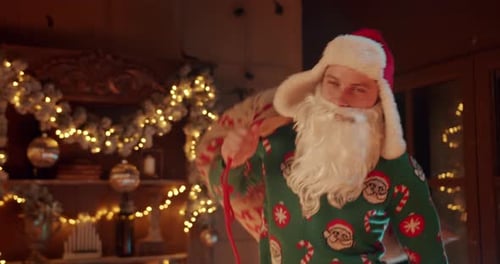 Young Man in Santa Claus Costume Bring Huge Bag with Gifts on Back at Christmas