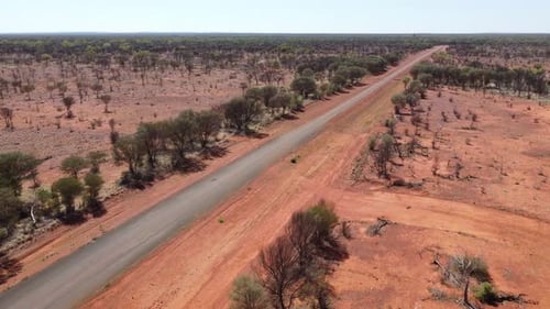 Drone flying then ascending over a sealed deserted country road in the Australian Outback