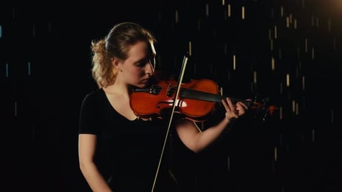 Female Violinist Playing Violin on a Dark Stage