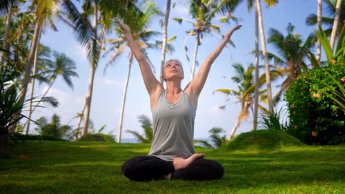 Woman Practices Yoga Amongst Tropical Palm Trees