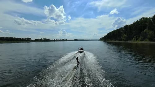 Wakesurfer-Training, Wakeboard-Fähigkeiten hinter dem Boot, die Flusswellen hinunter, Luftbild.