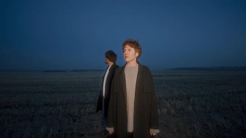 Couple Standing Together in Field and Looking around in Evening