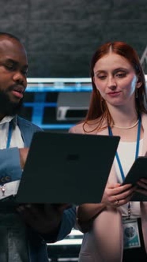 Two Professionals Discussing Data with Laptop and Tablet