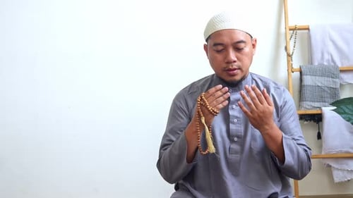 Man with Prayer Beads Praying Indoors