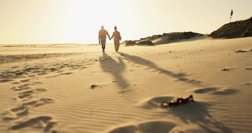 Couple, holding hands and walking on beach, sunset and bonding together on vacation at sea