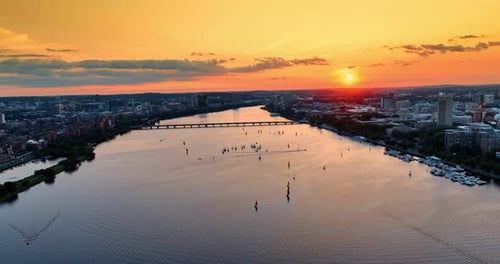 Flying above the Charles River in Boston. Splendid cityscape and waterscape in orange rays