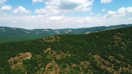 Lush Green Mountains Stretching Under a Cloudy Sky