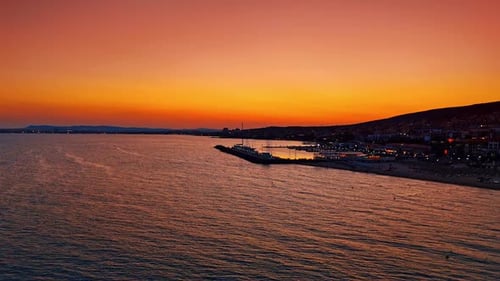 Bright sunset over the sea with golden sky and reflections on water.