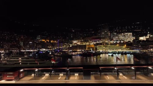 Aerial establishing shot of the Montel Carlo port at night underlights