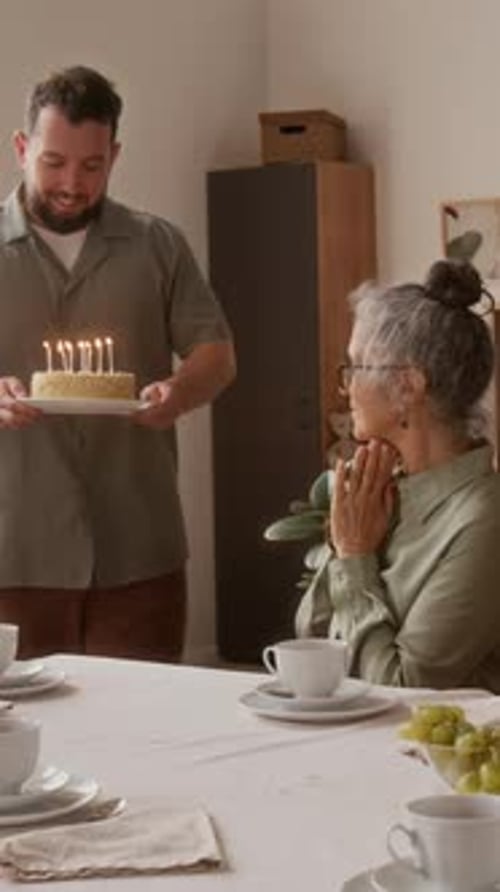 Family Celebrates Birthday with Cake and Gift Indoors
