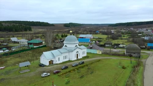 Aerial View of a Traditional Orthodox Church in a Summer Village Clip Flying Above Countryside Area