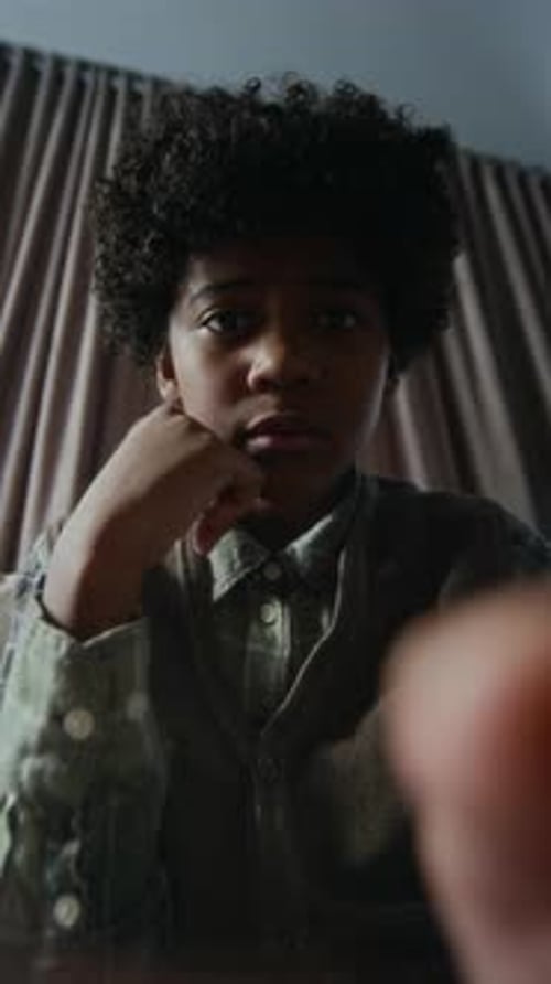 POV von Black Boy, der durch eine Hassnachricht scrollt und eine Antwort auf dem Smartphone eingibt
