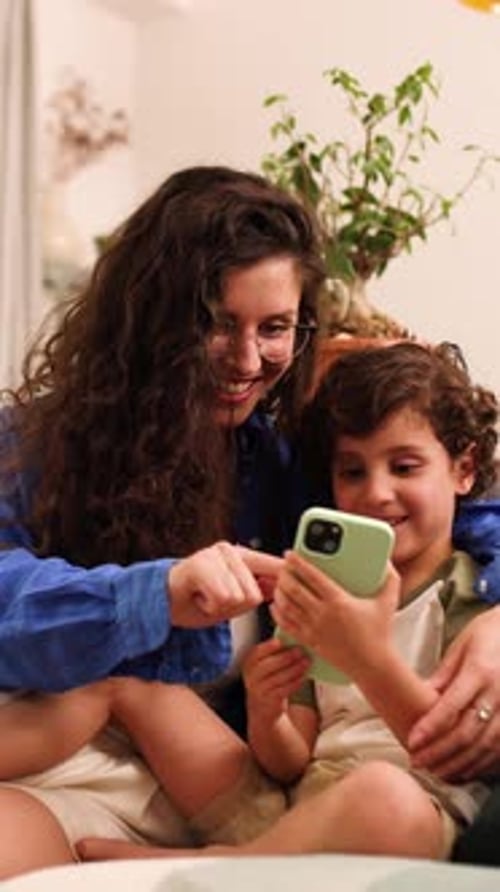 Woman and Child Looking at Phone at Home
