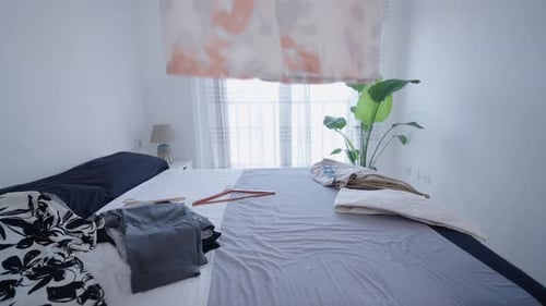 Messy bed with clothes in a minimalist room